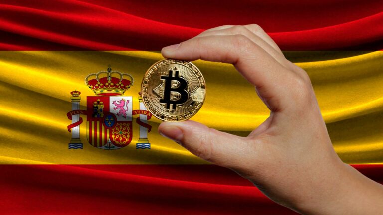 Moneda de bitcoin con fondo bandera de España.